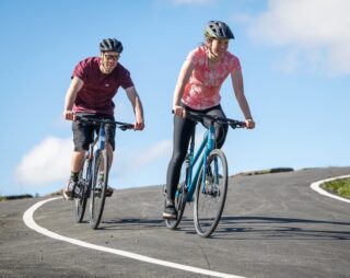 Man and woman riding Marin Fairfax bikes, on a road in the Welsh countryside.