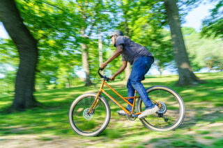 Rider taking a Marin Larkspur 2 through a wooded park.