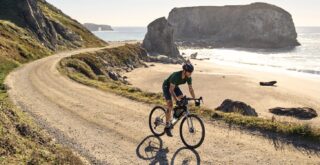 Four Corners 2 rider on a gravel road alongside the ocean.